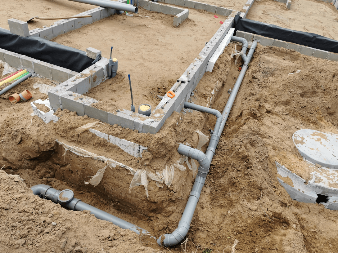 Aangelegde riolering met pvc-buizen in de grond rond een woning in Limburg