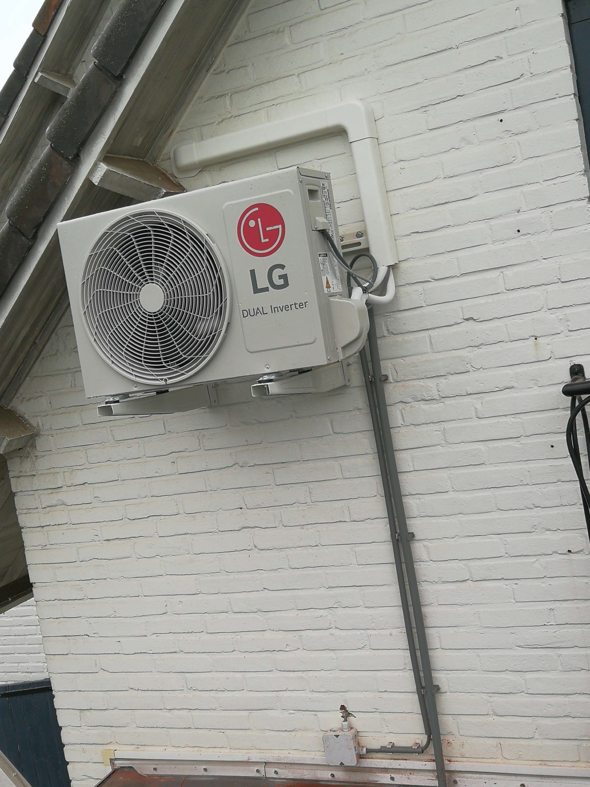 LG DUAL Inverter airco-buitenunit geplaatst tegen een wit geschilderde gevel in Limburg